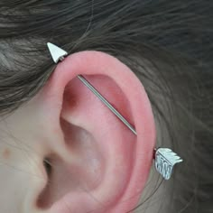 an ear piercing with two silver arrows on it