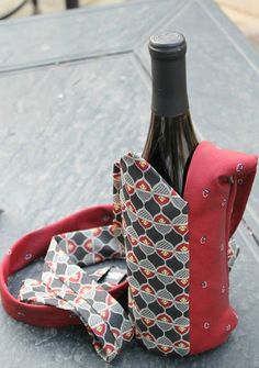 a bottle of wine sitting on top of a table with a bow tie around it