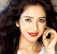 a woman with long dark hair and red lipstick is posing for a photo while holding her hand to her ear