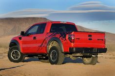 a red pick up truck parked in the desert