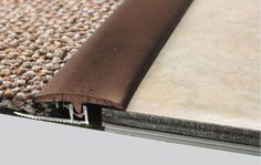 a close up view of the edge of a rug with a brown strip on it