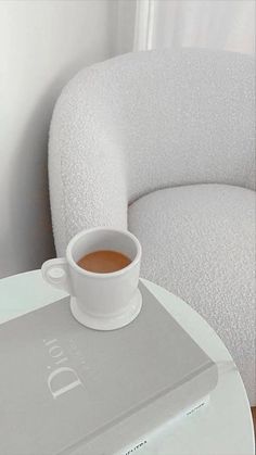 a cup of coffee sitting on top of a white table