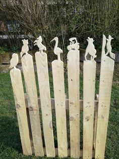 a wooden fence made out of pallet wood with sculptures on the top and bottom