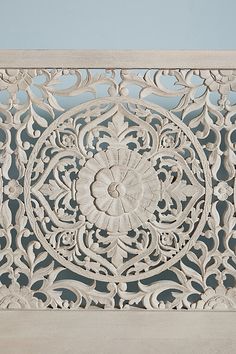 an intricately carved panel on the side of a building with blue sky in the background