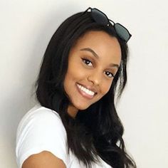 a woman in white shirt and sunglasses posing for the camera with her hand on her hip