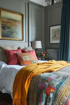 a bed with colorful blankets and pillows in a bedroom next to a chandelier