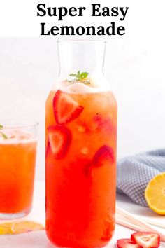 a pitcher filled with lemonade next to sliced strawberries