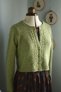 a woman's green cardigan sweater on a mannequin headdress