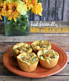 mini green bean casserole cups on an orange plate with flowers in the background