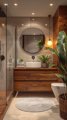 a bathroom with a sink, toilet and shower in the corner next to a potted plant