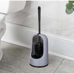 a gray toilet brush holder on the floor