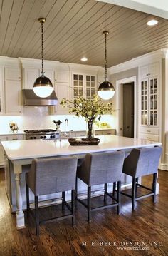 a large kitchen island with four chairs around it