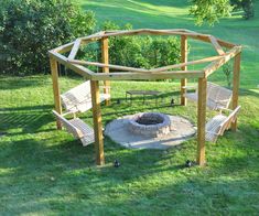 an outdoor fire pit surrounded by wooden benches