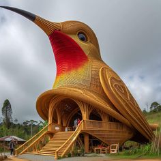 a large bird shaped building with stairs leading up to it's entrance and people standing outside