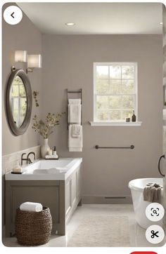 a bathroom with white fixtures and gray walls