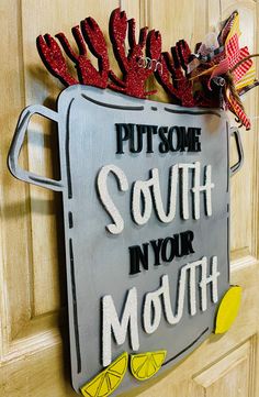 a metal sign that says put some south in your mouth on the front door with red and yellow decorations