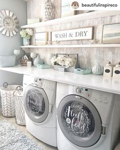 a washer and dryer in a room with pictures on the wall behind them