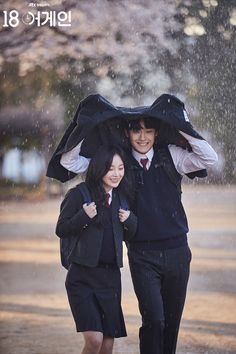 two people walking under an umbrella in the rain