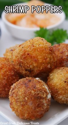 Deep fried shrimp poppers on a plate with a small bowl of dipping sauce in the background.