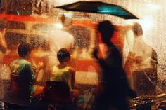 a blurry photo of people standing under an umbrella