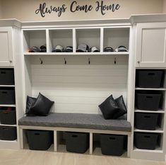 a room with some white cabinets and black bins on the wall next to it