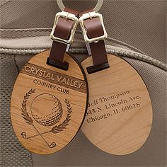 two wooden golf tags attached to a backpack with brown straps and matching leather trims