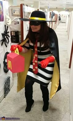 a woman dressed up as a mcdonald's character holding a box with a knife in her hand