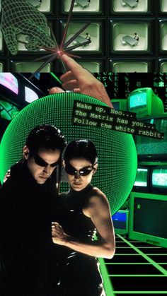 two people standing next to each other in front of computer screens and green lights, one holding a cell phone