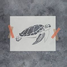 a drawing of a turtle on a piece of paper with orange tape around it's neck