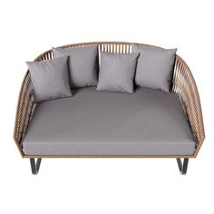 a wicker couch with four pillows on the top and bottom, in front of a white background