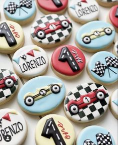 decorated cookies with cars and numbers are arranged on a white table top, including one for the number one