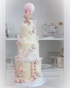 a three tiered cake with teddy bears on top