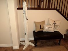 a black chair sitting under a stair case next to a wooden bannister with letters on it