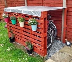 a bike is parked in front of a red fence with potted plants on it