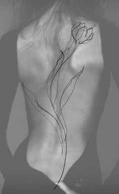 the back of a woman's body with a flower drawn on it