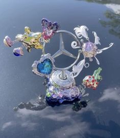 a car hood ornament with many different colored glass items on it's surface