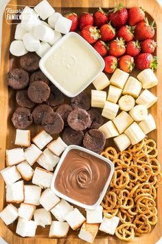 a platter filled with pretzels, marshmallows, and other snacks