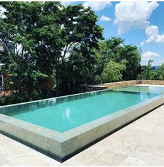 an empty swimming pool with trees in the background