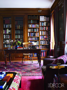 a living room filled with lots of furniture and bookshelves next to a window