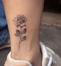 a rose tattoo on the ankle is shown in this black and white photo, it looks like