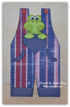 an image of a frog in the pocket of a pair of overalls that is made out of fabric