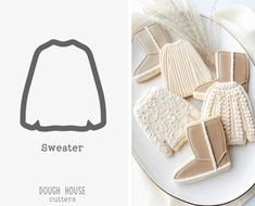 some knitted sweaters and mittens are on a plate next to the words, sweater