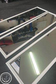 two mirrors sitting next to each other on top of a table with a light in the middle