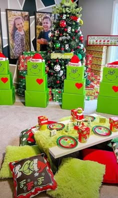 the christmas tree is decorated in green and red, with presents on the floor next to it