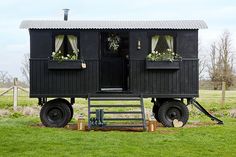 a black caboose with plants on the windows