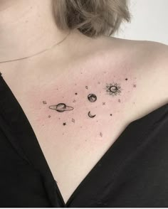 a woman's upper back tattoo with planets and stars on her left side shoulder