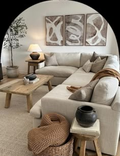 a living room with couches, tables and two paintings on the wall above them