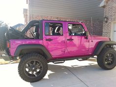 a pink jeep parked in front of a house