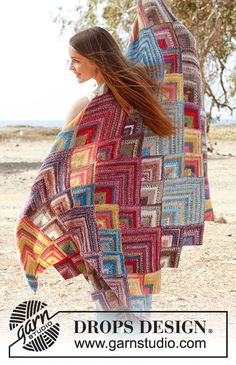 a woman is wrapped up in a colorful blanket