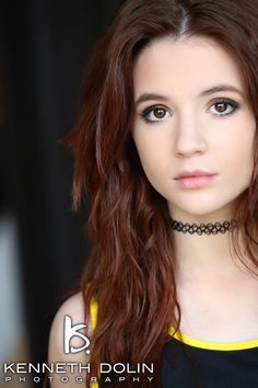 a beautiful young woman with long red hair wearing a choker and black dress posing for a photo